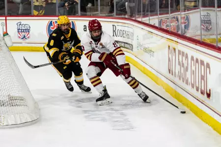 Brady Berard with puck along the boards against AIC