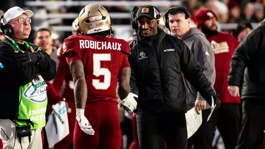Savon Huggins celebrates a touchdown with Kye Robichaux on the sideline.