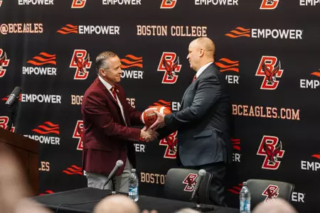 AD Blake James hands a football to Bill O'Brien after introducing him as the 37th head coach in BC football history.