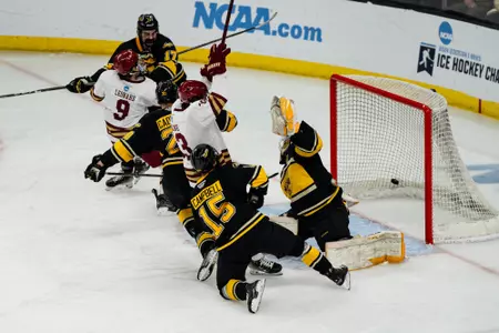 Ryan Leonard is upended as the puck from his shot crosses into the net vs. Michigan Tech.