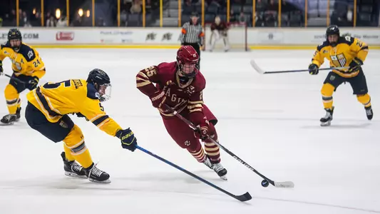 Jake Sondreal skating with puck at Merrimack