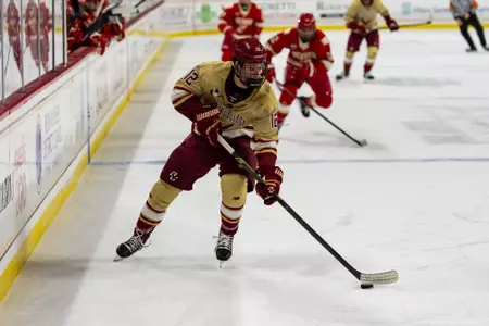 Jake Sondreal skating along the boards with the puck against Denver