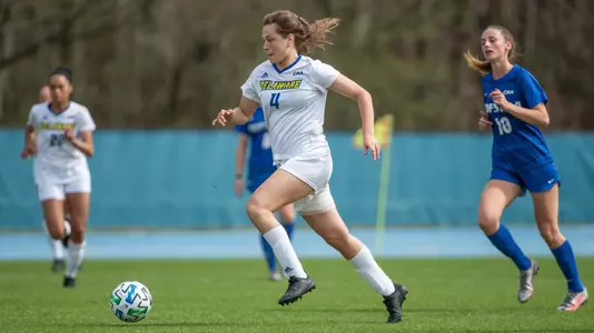 Laura Fluegge dribbles the ball past Hofstra defenders