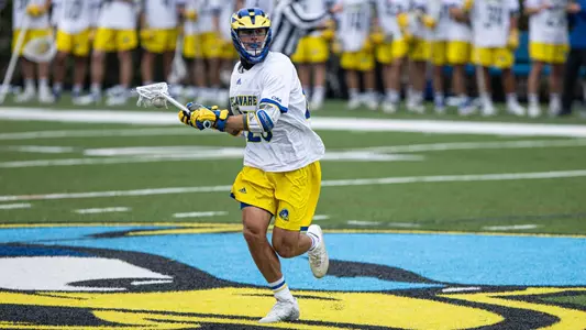 Delaware player rushes down the field with the ball in his stick