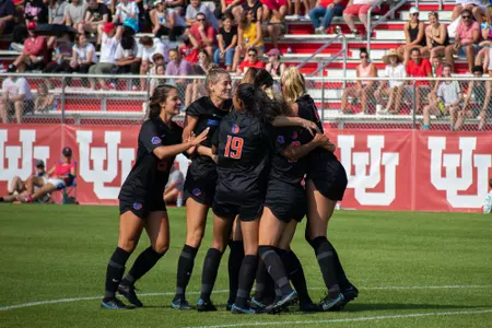 Boise State soccer players celebrate after scoring a goal.