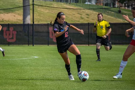 Boise State soccer player Dorian Goodwin dribbles past a defender.