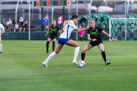 Boise State soccer player Dorian Goodwin dribbles past a defender.