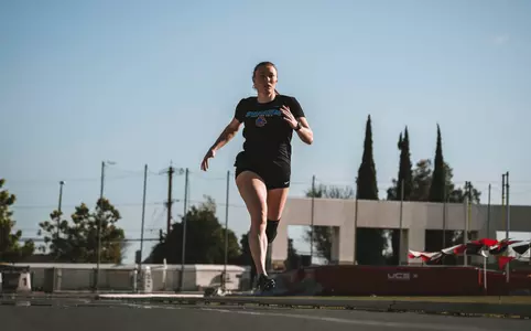 Abby Stamper runs in pre-meet at Aztec Invitational.