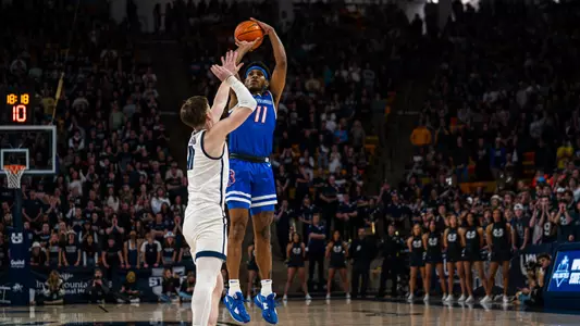 Chibuzo Agbo shoots a 3-pointer over an Aggies defender in a game at Utah State on March 4, 2023.
