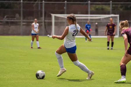 Kenzie MacMillan dribbling ball across the field against Arizona State.