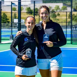 Nicole Discenza and Lorelyz Marruffo posing together for a photo with their trophy.