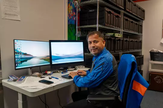 Raul Ibarra sits at his desk in the Varsity Center equipment room.