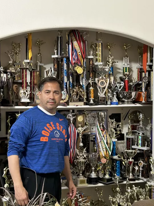 Raul Ibarra standing in front of a trophy case.