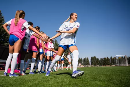 Kayla Soderstrom giving high-fives as she runs down the line.