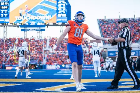 Austin Bolt hands the ball to the officall following a touchdown reception as No. 21 Boise State defeated Utah State 62-30 in the conference opener at Albertsons Stadium on Oct. 5, 2024. (Photo by Kenna Harbison).