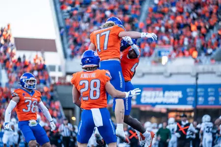 Clay Martineau and Seth Knothe celebrate with Dylan Riley following Riley's kickoff return for a touchdown as No. 21 Boise State defeated Utah State 62-30 in the conference opener at Albertsons Stadium on Oct. 5, 2024. (Photo by Kenna Harbison).