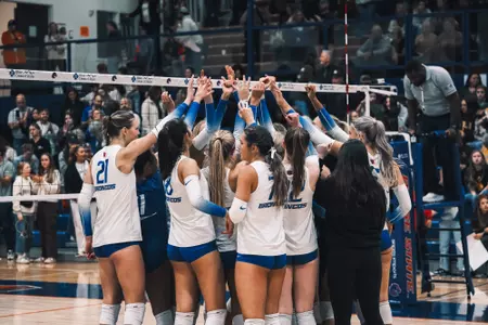 The team dress in white uniforms huddling up during the Wyoming match in Boise on November 7, 2024.