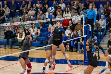 Kiki Remensperger one-hand sets the ball at the net during the San Diego State match in Boise during 2024.
