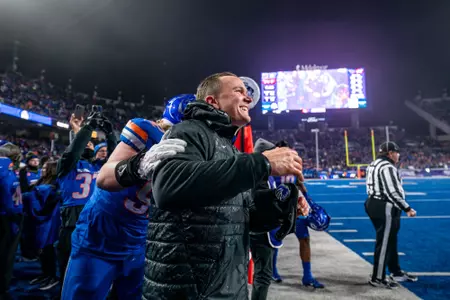 Spencer Danielson celebrates with players on the sideline after winning 2024 Mountain West title