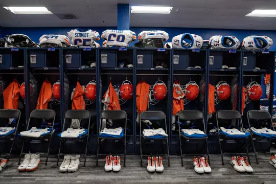 Football lockers with jerseys, pads and helmets organized inside.