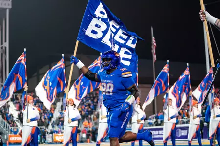 Herbert Gums runs the Bleed Blue flag out onto the field during pregame festivities at the Mountain West Championship game in Boise on December 6, 2024.