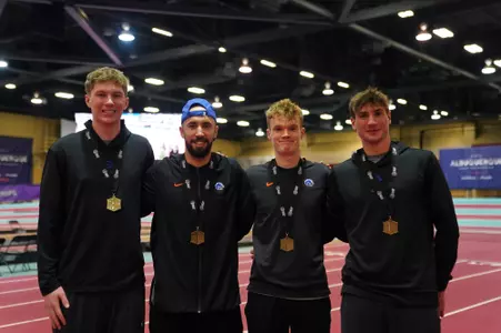 Men's distance medley relay team with their medals.