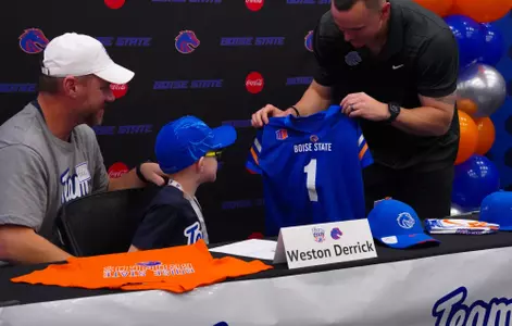 Weston Derrick receives a Boise State jersey from head coach Spencer Danielson as part of his Team Impact signing.