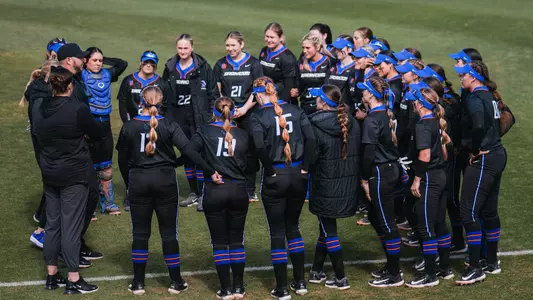 Softball team huddle down right field foul line at Arizona State, February 2024.