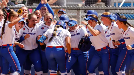 Alycia Flores is greeted at home plate by her teammates after a game-tying home run.