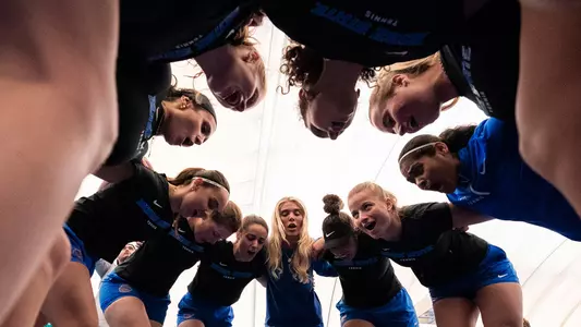 Women's tennis team huddle.