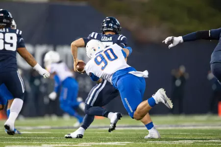 Boise State defensive tackle Braxton Fely makes a tackle and celebrates at Utah State in 2023.