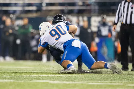 Boise State defensive tackle Braxton Fely makes a tackle and celebrates at Utah State in 2023.