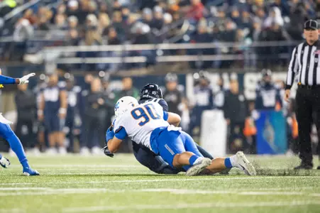 Boise State defensive tackle Braxton Fely makes a tackle and celebrates at Utah State in 2023.