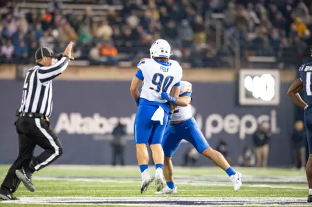 Boise State defensive tackle Braxton Fely makes a tackle and celebrates at Utah State in 2023.