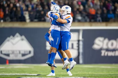 Boise State defensive tackle Braxton Fely makes a tackle and celebrates at Utah State in 2023.