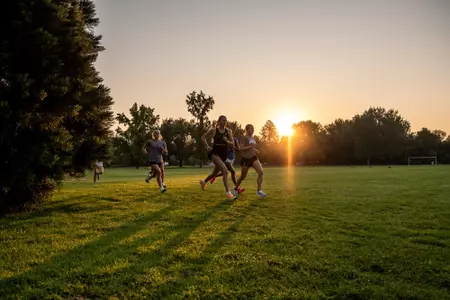 Members of the women's cross country team running at Ann Morrison during practice