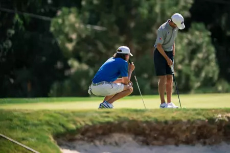 Gavyn Knight reads the green while Cole Rueck lines up a putt in a practice at Crane Creek Country Club in 2024.