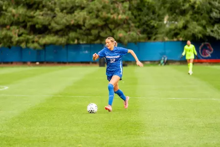 Kayla Soderstrom, in a blue jersey, dribbles the ball.