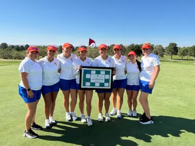 Women's golf team with their trophy after winning the Golf Iconic Classic