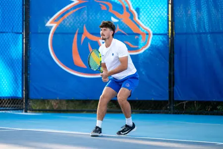 Carson Baker with two hands on his racket