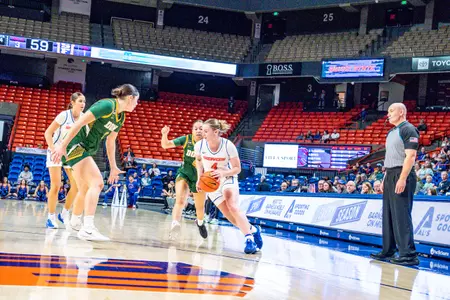 Dani Bayes dribbles the ball against USF defenders.