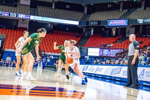 Dani Bayes dribbles the ball against USF defenders.
