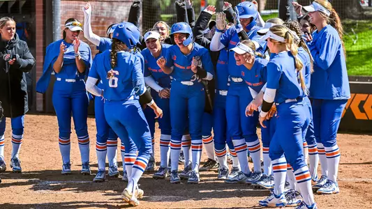 Megan Lake greeted at home plate after hitting a home run.