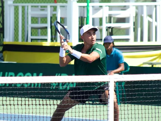 John Chin waiting at the net to return a volley with his backhand during a Davis Cup match.