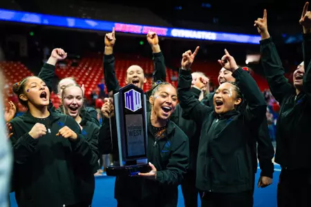 Boise State gymnastics celebrating with the MW regular season trophy.