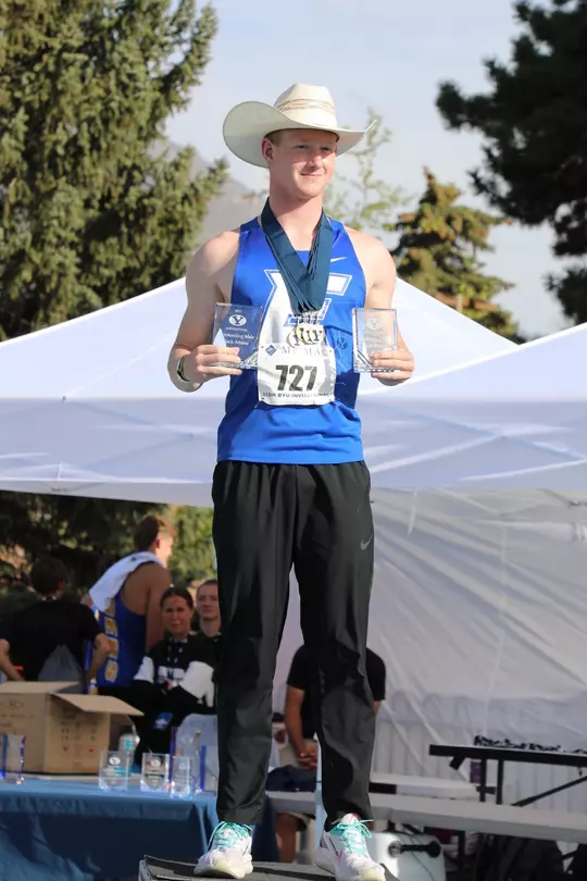 Landon Helms in high school at the BYU Invitational holding trophies