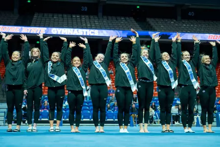 Boise State gymnastics seniors raise their arms after 2025 senior ceremony