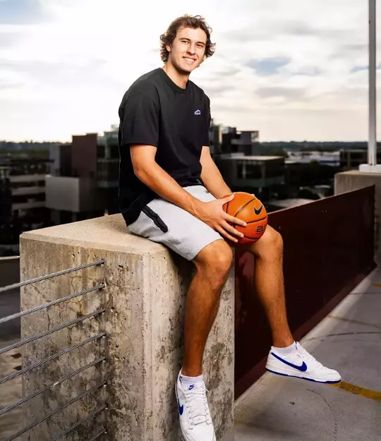 Tyson Degenhart poses with basketball on a rooftop