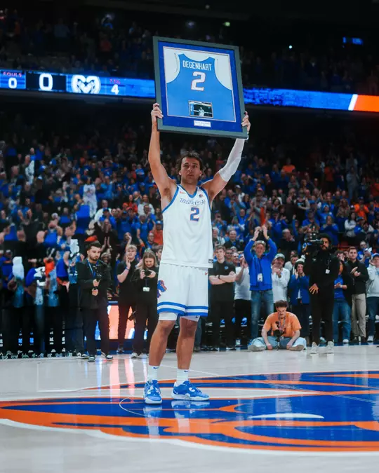 Tyson Degenhart holds framed jersey at center court during senior night pregame festivities