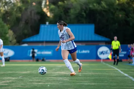 Olivia Collins, white jersey runs with the ball at Portland State